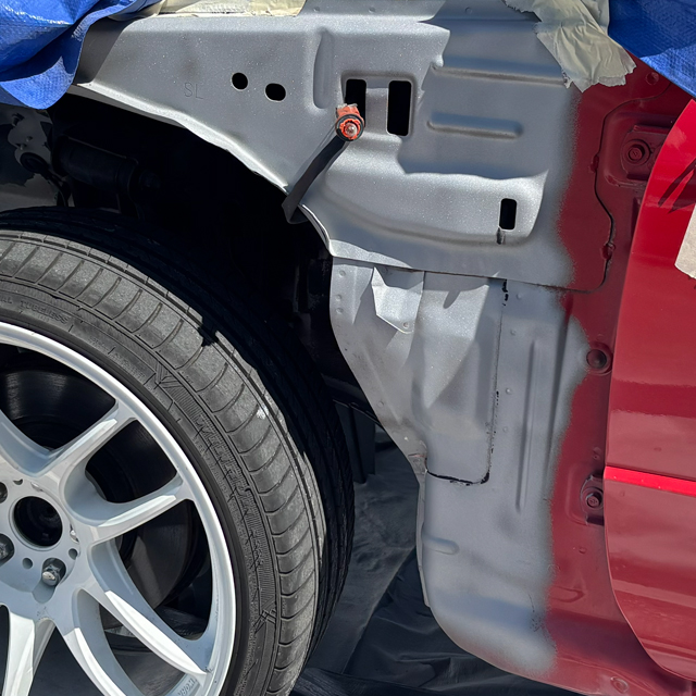 Red auto body paint being removed with dust free sand blasting